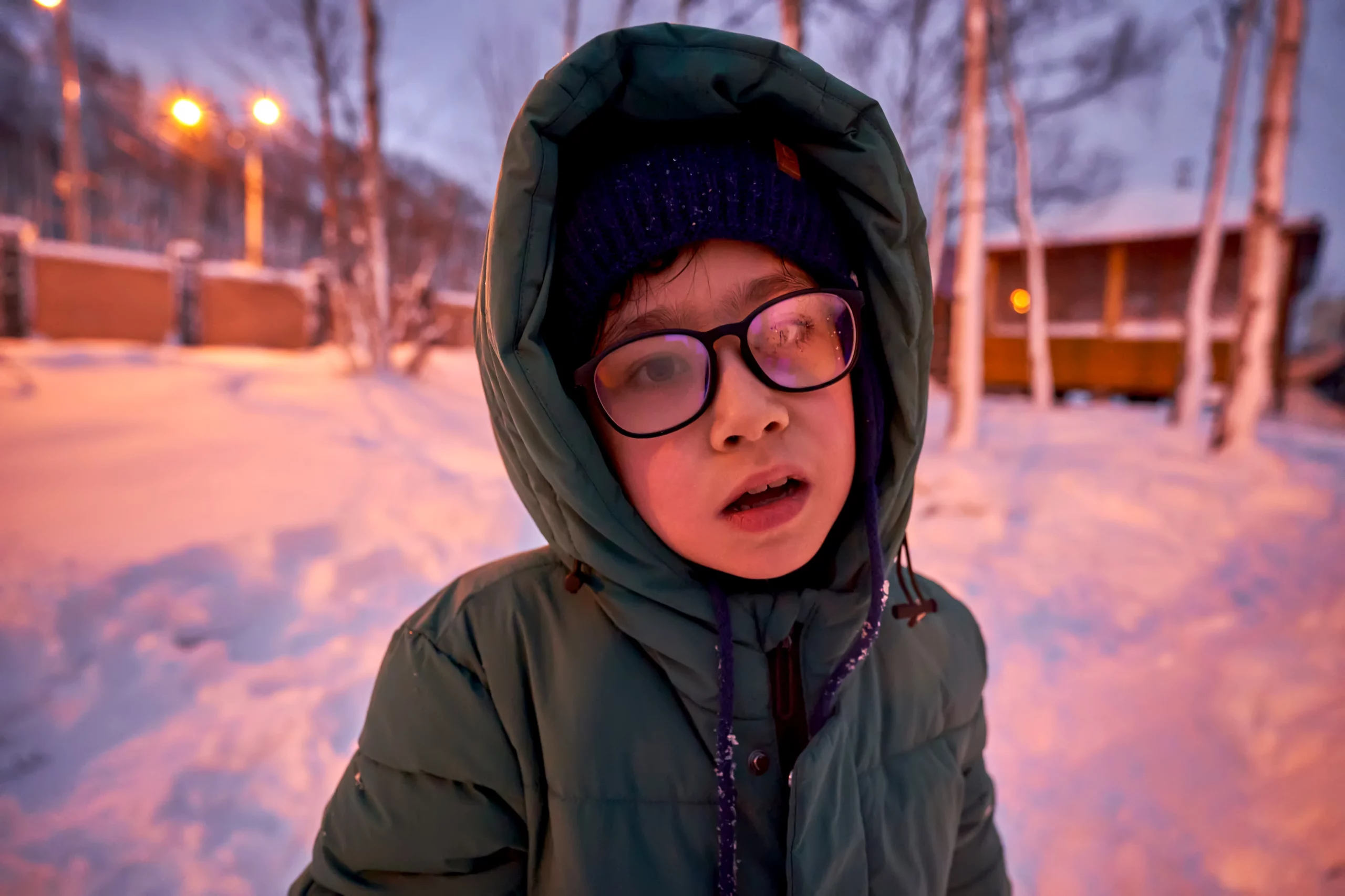 Kleiner Junge mit beschlagener Brille im Winter.
